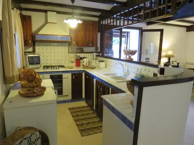 a large kitchen with a sink and a stove at Casale Giulietta in Scopello