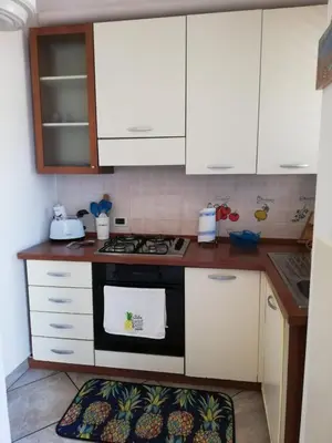 a kitchen with white cabinets and a stove top oven at By the Sea in Terrasini