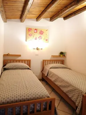 two beds in a room with wooden ceilings at Casa Marcella San Vito Lo Capo in San Vito lo Capo