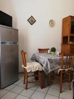 a kitchen with a table with chairs and a refrigerator at Casa Marcella San Vito Lo Capo in San Vito lo Capo