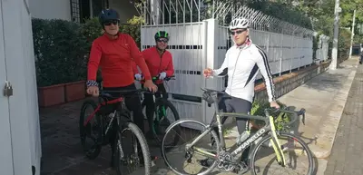 three men standing with their bikes next to a fence at Guest House Antichi Ulivi in Mondello