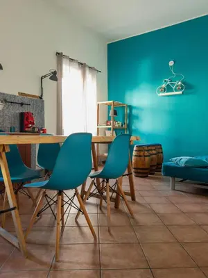 a dining room with a wooden table and blue walls at GiuiuzzaMia in Palermo