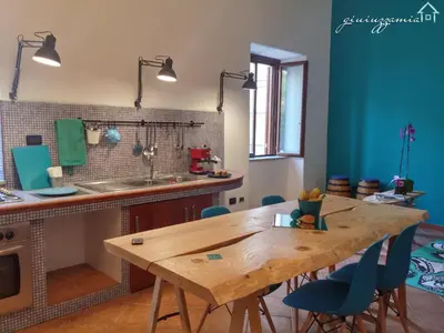 a kitchen with a wooden table and blue chairs at GiuiuzzaMia in Palermo