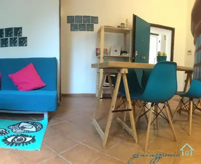 a living room with a table and blue chairs at GiuiuzzaMia in Palermo