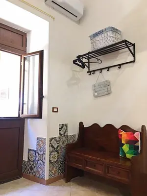 a room with a bench and a shelf on a wall at Alice's Apartment in Castellammare del Golfo