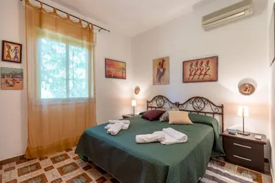 a bedroom with a green bed with towels on it at Villa Violetta in Carini