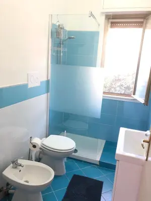 a blue and white bathroom with a toilet and a sink at Villa Violetta in Carini