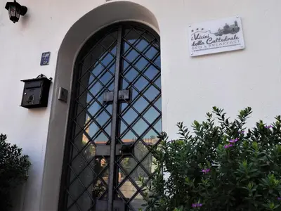a door with a sign on the side of a building at I Vicini della Cattedrale in Palermo