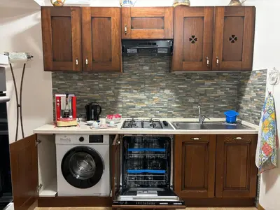 a kitchen with a washing machine and a sink at Ashur apartments in Mondello