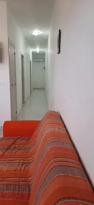 a room with a red couch and a hallway at Casa Rachele ad Alcamo Marina in Alcamo Marina