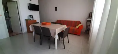 a table and chairs in a living room with a couch at Casa Rachele ad Alcamo Marina in Alcamo Marina