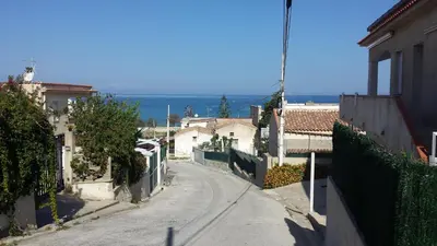 an empty street with buildings and the ocean in the background at Casa Rachele ad Alcamo Marina in Alcamo Marina