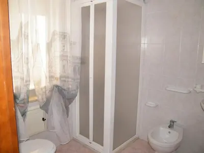 a white bathroom with a toilet and a sink at Casa Rachele ad Alcamo Marina in Alcamo Marina