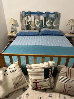 a bedroom with a bed with a blue comforter and pillows at Villa Eco-Chic in Carini