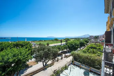 a view of a street with trees and the ocean at Amazing Sea View in Historic Building in Downtown by Wonderful Italy in Palermo