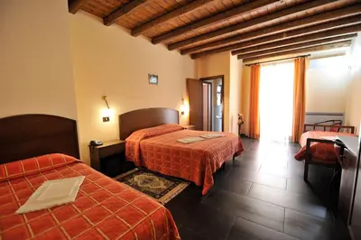 a hotel room with two beds and a window at Hotel Piccolo in Termini Imerese
