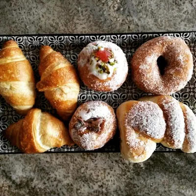 a tray of donuts and croissants on a table at Ad Hoc Rooms in Palermo