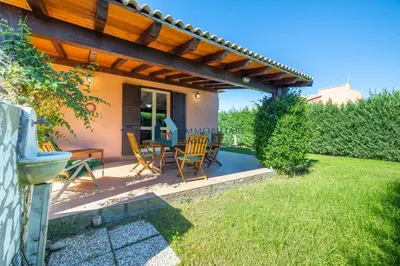 a patio with a table and chairs under a pergola at Villa Limuti con piscina condominiale in Campofelice di Roccella