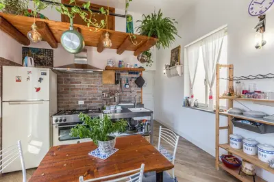 a kitchen with a wooden table and a refrigerator at Gò Gò House 2 Casa Aprile in Palermo