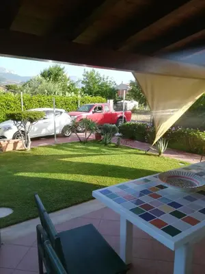 a checkered table in a yard with cars parked at Villa Mimmo in Lascari