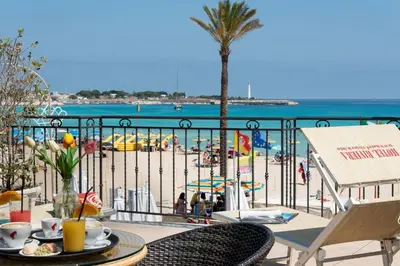 a balcony with a view of the beach and the ocean at Hotel Riviera in San Vito lo Capo
