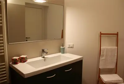 a bathroom with a white sink and a mirror at Re Federico Apartment in Palermo