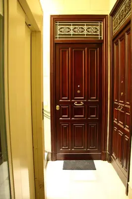 a wooden door in a hallway with a tile floor at Re Federico Apartment in Palermo