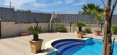 a swimming pool with two potted plants in a yard at 25min da Cefalù e Palermo Piscina pvt, 4camere, 150m dal mare in Trabia