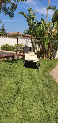 a lawn with a chair in the grass at 25min da Cefalù e Palermo Piscina pvt, 4camere, 150m dal mare in Trabia