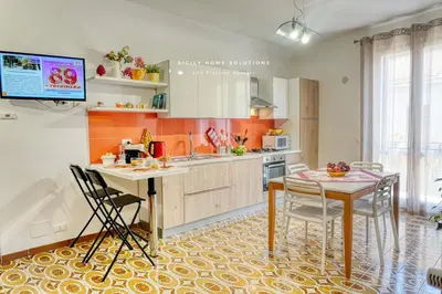 a kitchen with a table and chairs and a tv at Casa dei Coralli Panoramic Sea View Centro Storico By Sicily Home Solutions in Castellammare del Golfo