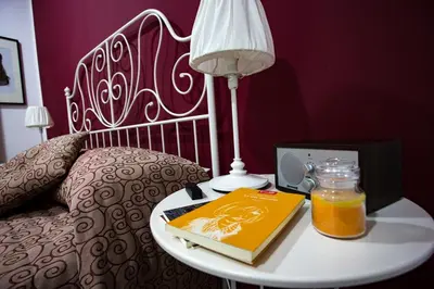 a bed with a table with a book and a lamp at Casa Florio Appartamenti in Palermo