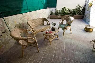 three wicker chairs and a table on a patio at Casa Florio Appartamenti in Palermo
