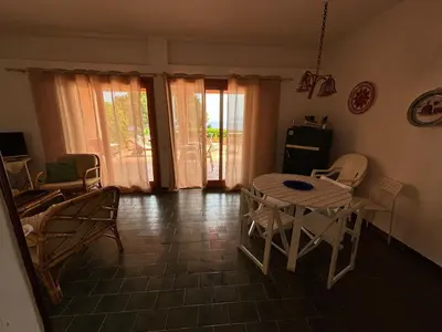 a dining room with a table and chairs in a room at Villa Hibiscus Scopello in Scopello