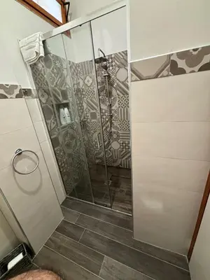 a shower with a glass door in a bathroom at Villa Hibiscus Scopello in Scopello