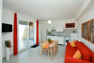 a living room with a red couch and a table at Villa Barbara...a 100 passi dal mare!!!! in Lascari