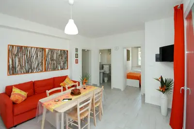 a living room with a red couch and a table at Villa Barbara...a 100 passi dal mare!!!! in Lascari