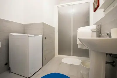 a white bathroom with a sink and a shower at Villa Pasquale...immersa nella tranquillita' in Lascari