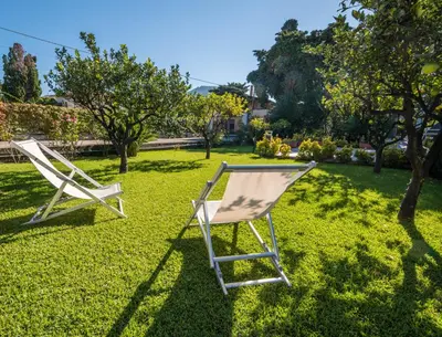 two chairs sitting on the grass in a yard at Villa Francesco...graziosa, moderna, confortevole! in Lascari