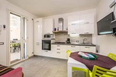 a kitchen with white cabinets and a table with yellow chairs at Villa Francesco...graziosa, moderna, confortevole! in Lascari