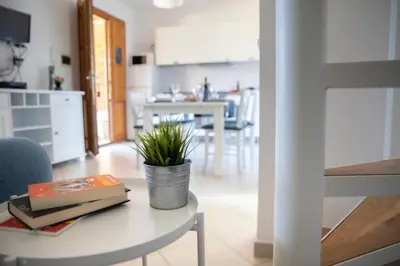 a living room with a table with a plant on it at Riva Sea Apartments in Castellammare del Golfo