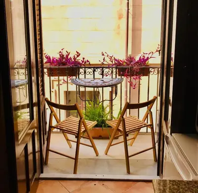 a table and two chairs on a balcony with flowers at Casa Vigliena in Palermo
