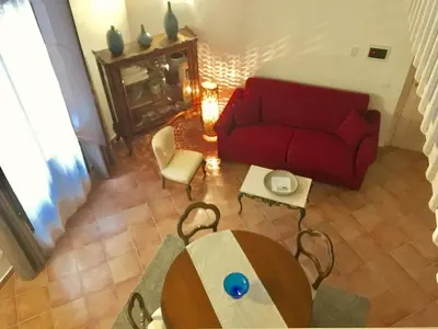 a living room with a red couch and a table at Casa Vigliena in Palermo