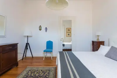 a bedroom with a bed and a blue chair at Luxury Apartment * Immo's House* in Palermo