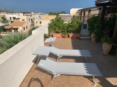 two lounge chairs and tables on a balcony at Blu Terrace in San Vito lo Capo