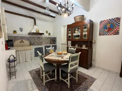 a table with chairs and a potted plant on a porch at Camidù Boutique House in Palermo