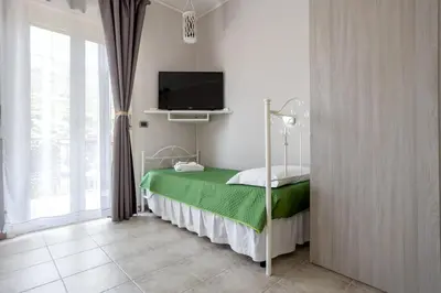 a bedroom with a bed with a tv on the wall at Villa Salvatore in Capaci