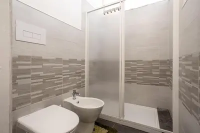 a bathroom with a toilet and a sink and a shower at Villa Salvatore in Capaci