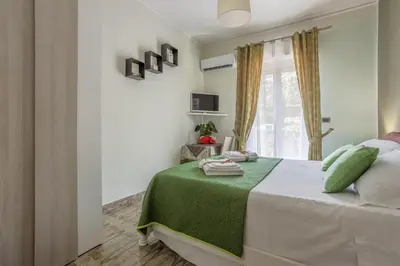 a bedroom with a bed with green sheets and a window at Villa Salvatore in Capaci