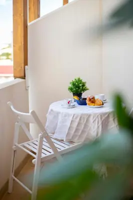 a table with a plate of food and a plant on it at Elisir Suite Rooms by Marino Tourist in San Vito lo Capo