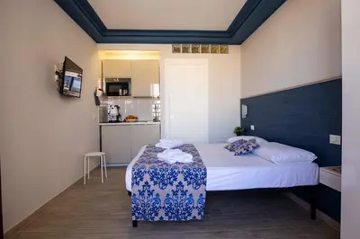 a small bedroom with a bed and a kitchen at Elisir Suite Rooms by Marino Tourist in San Vito lo Capo